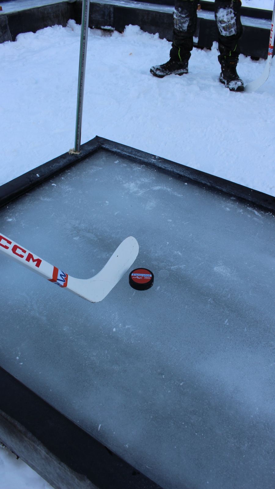 Schläger und Eisminigolf-Puck auf der Eisbahn